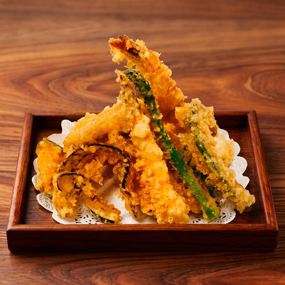 Crispy tempura shrimp, asparagus, and pumpkin slices arranged on a wooden tray with a white doily.